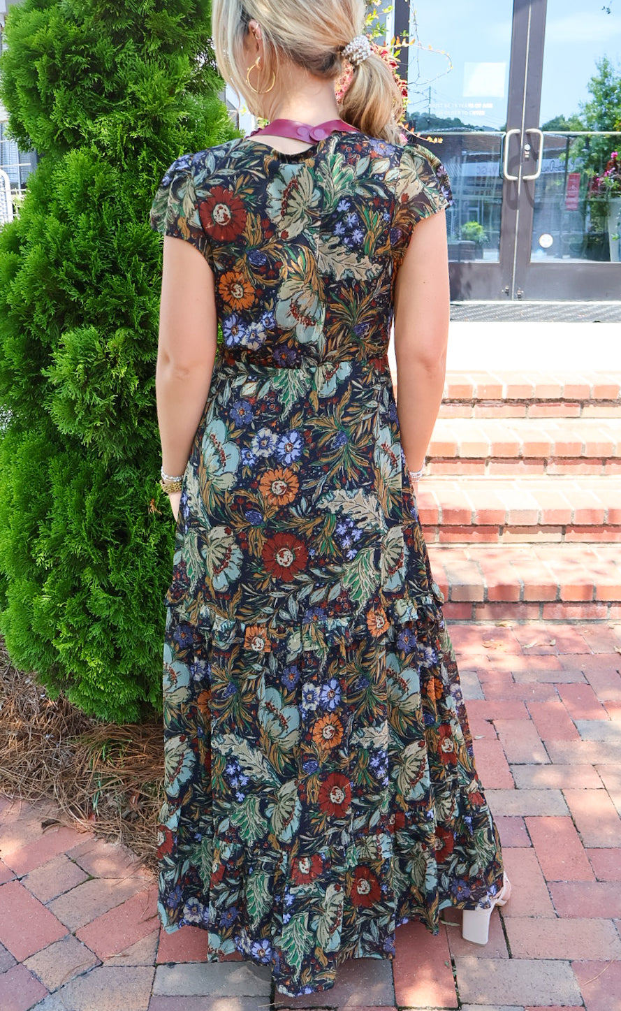 Bohemian floral maxi dress with a V-neck, flutter sleeves, and a tiered ruffle skirt