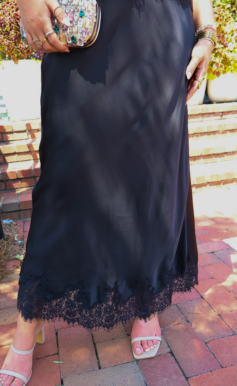 Black satin two-piece set with a lace-trim crop top and matching lace-trim skirt