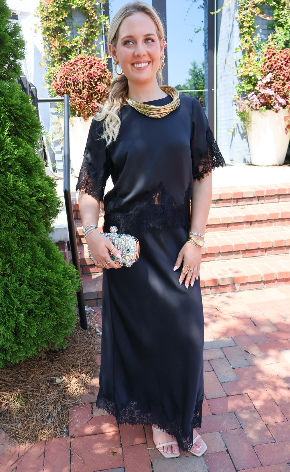 Black satin two-piece set with a lace-trim crop top and matching lace-trim skirt