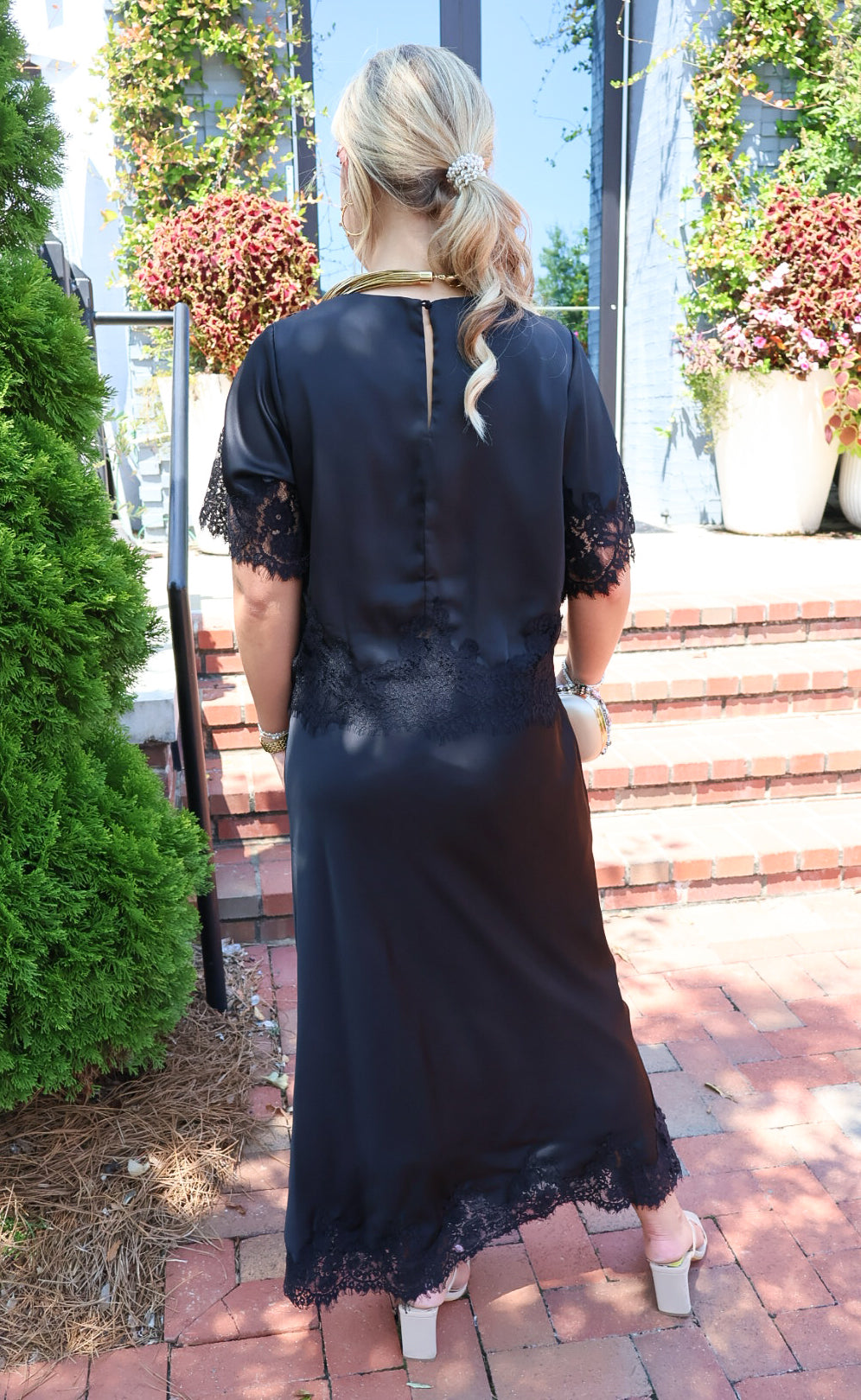 Black satin two-piece set with a lace-trim crop top and matching lace-trim skirt