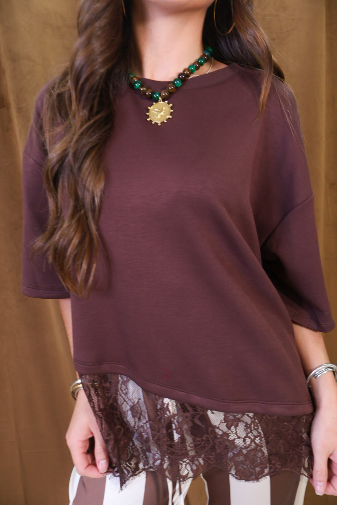 Brown Tee With Asymmetrical Lace Hem — close-up of asymmetrical lace hem.