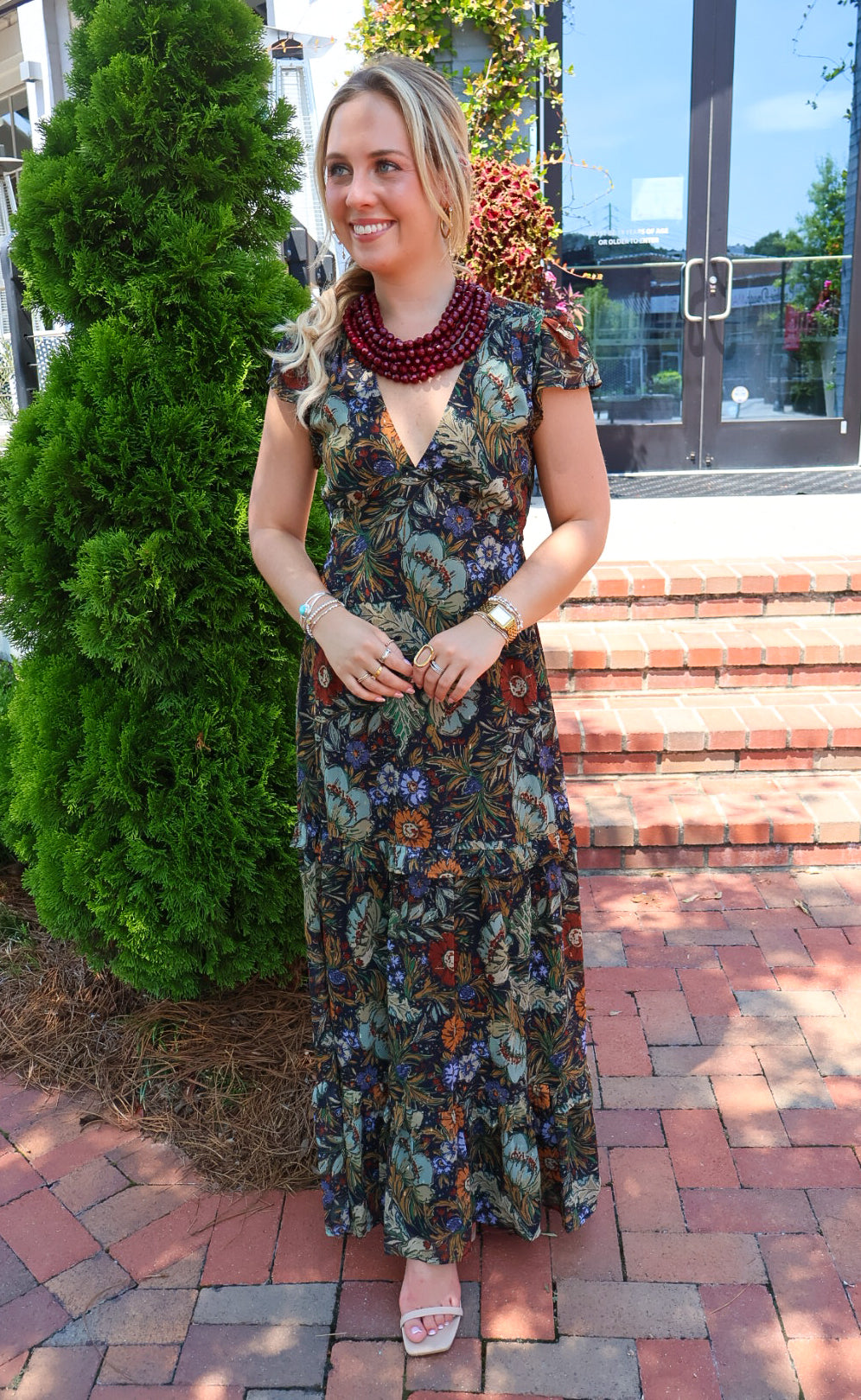 Bohemian floral maxi dress with a V-neck, flutter sleeves, and a tiered ruffle skirt