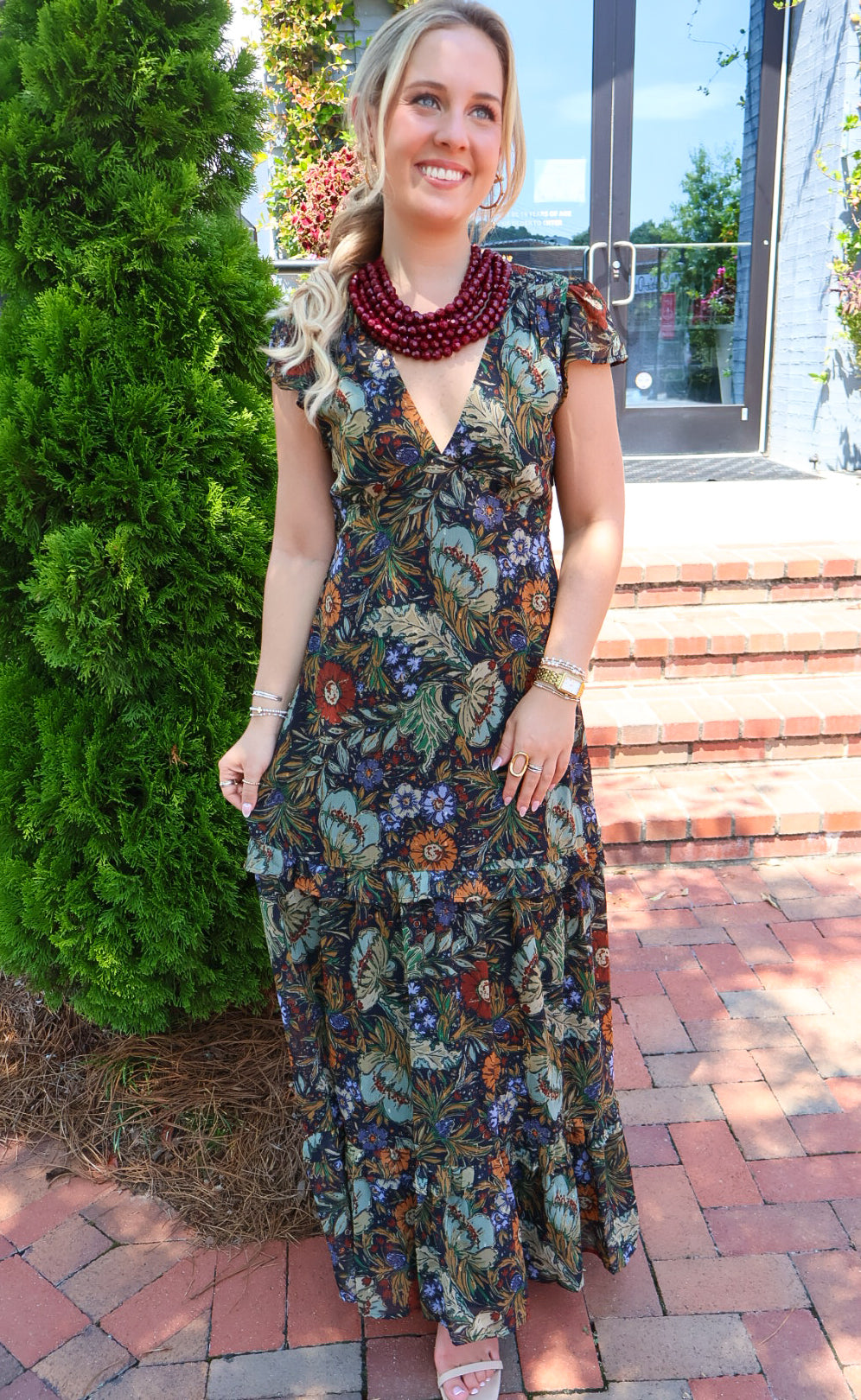 Bohemian floral maxi dress with a V-neck, flutter sleeves, and a tiered ruffle skirt