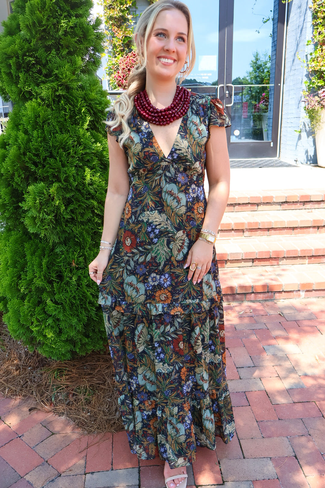 Bohemian floral maxi dress with a V-neck, flutter sleeves, and a tiered ruffle skirt