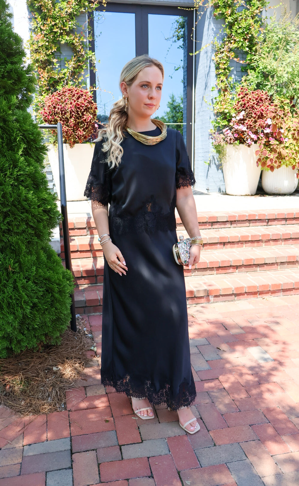 Black satin two-piece set with a lace-trim crop top and matching lace-trim skirt