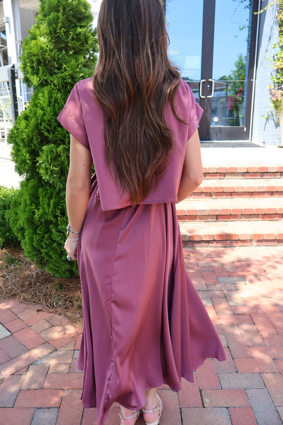 Mauve satin two-piece set with a boxy crop top and pleated midi skirt