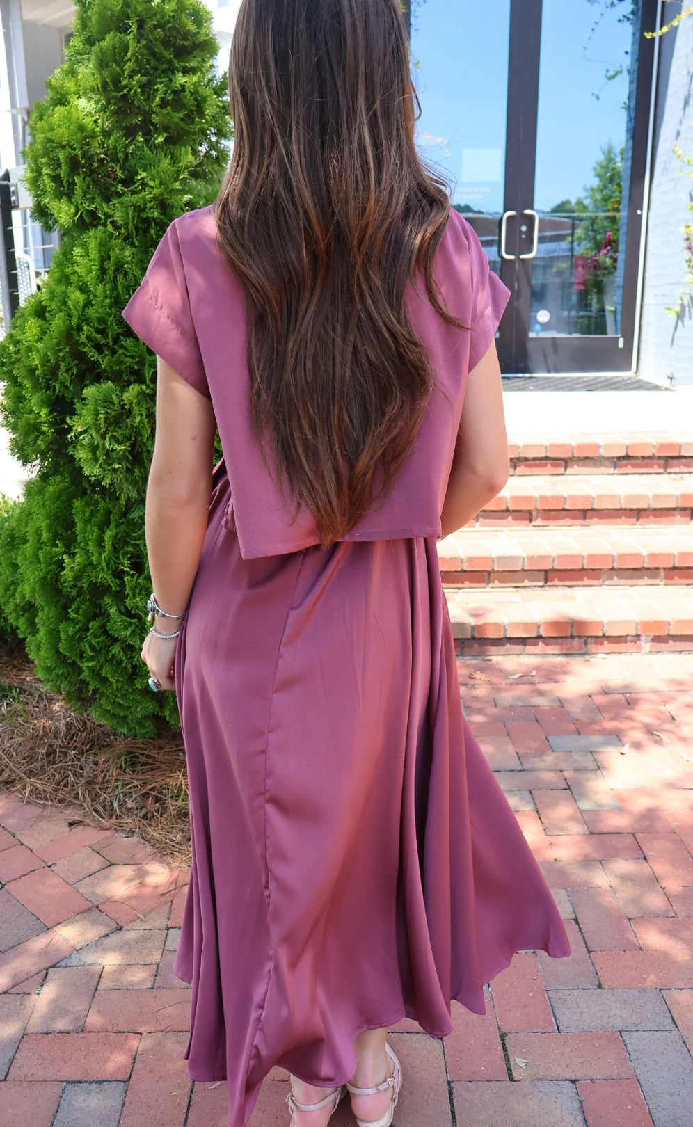 Mauve satin two-piece set with a boxy crop top and pleated midi skirt