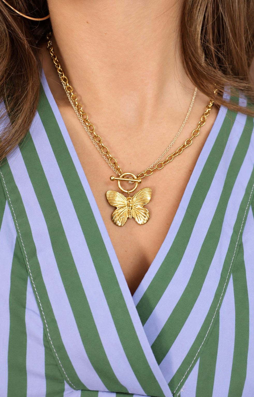 Gold butterfly toggle necklace worn by model