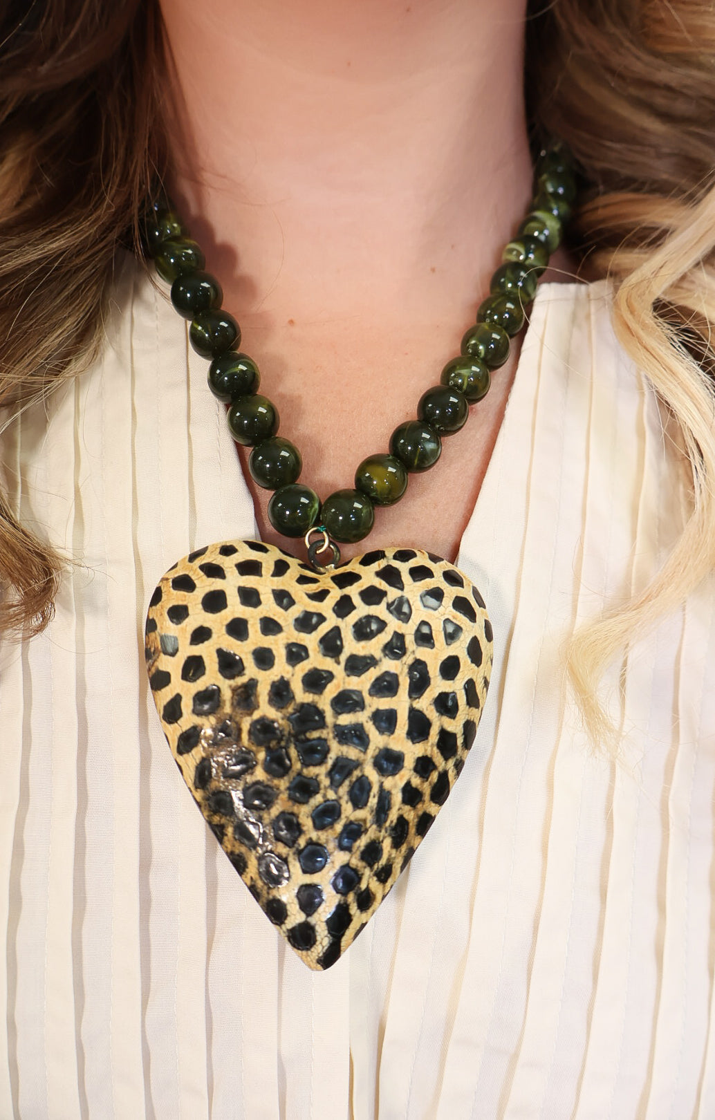 Oversized spotted wooden heart pendant on green beaded necklace