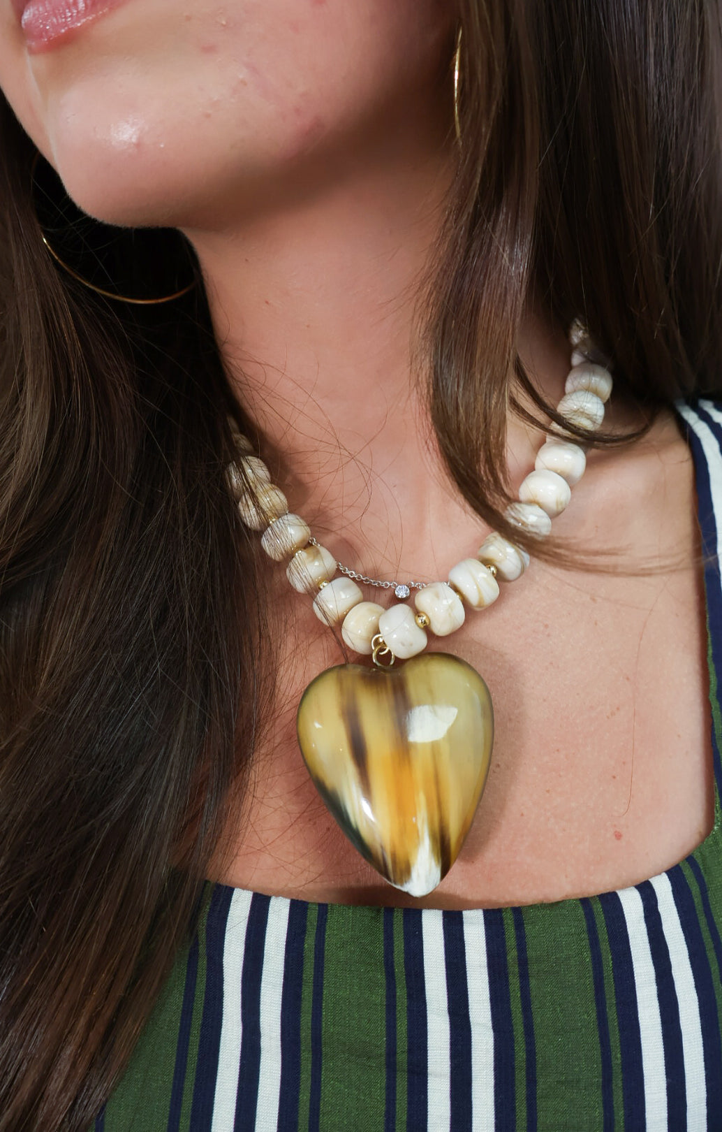 Reversible two-tone heart necklace shown on amber side