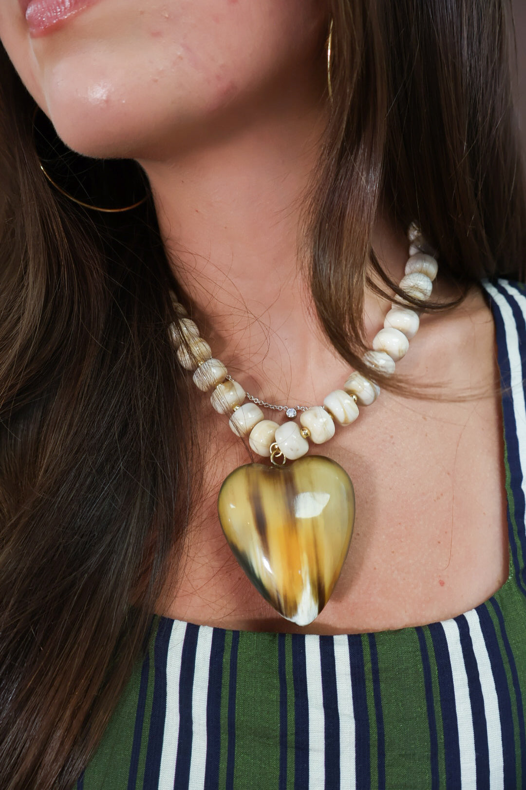 Reversible two-tone heart necklace shown on amber side