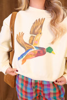 Cream cropped mallard graphic sweatshirt — close-up of flying mallard graphic and cropped hem.