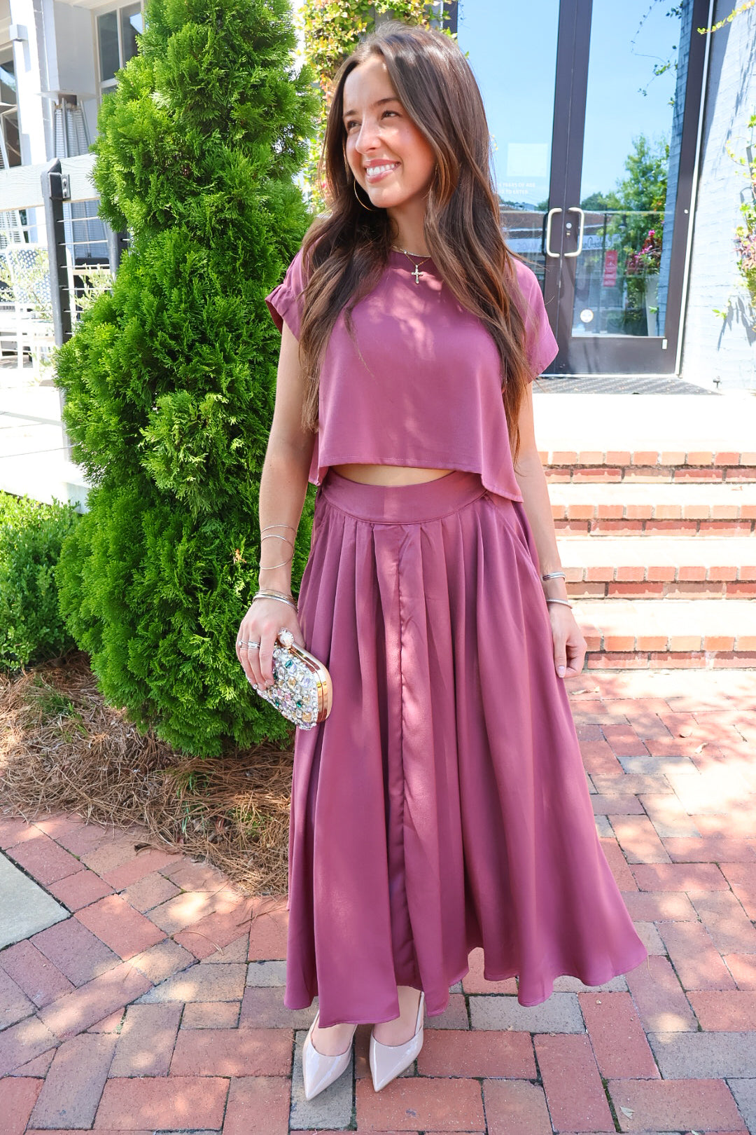 Mauve satin two-piece set with a boxy crop top and pleated midi skirt