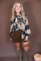 Black Floral Tie-Front Blouse — full outfit with tall boots.