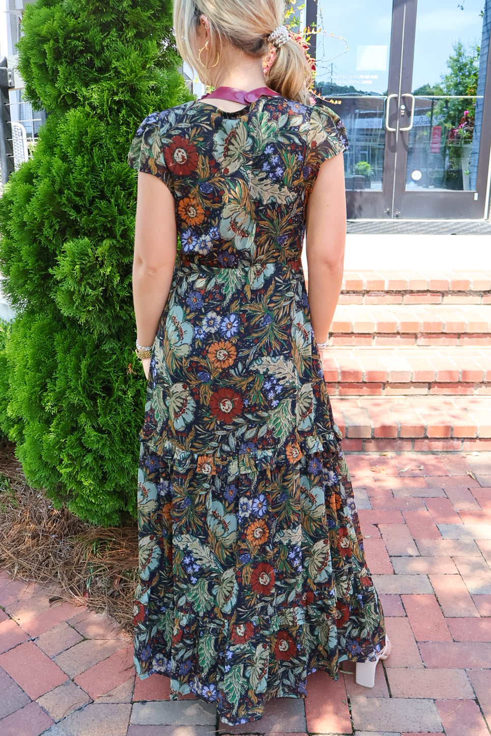 Bohemian floral maxi dress with a V-neck, flutter sleeves, and a tiered ruffle skirt