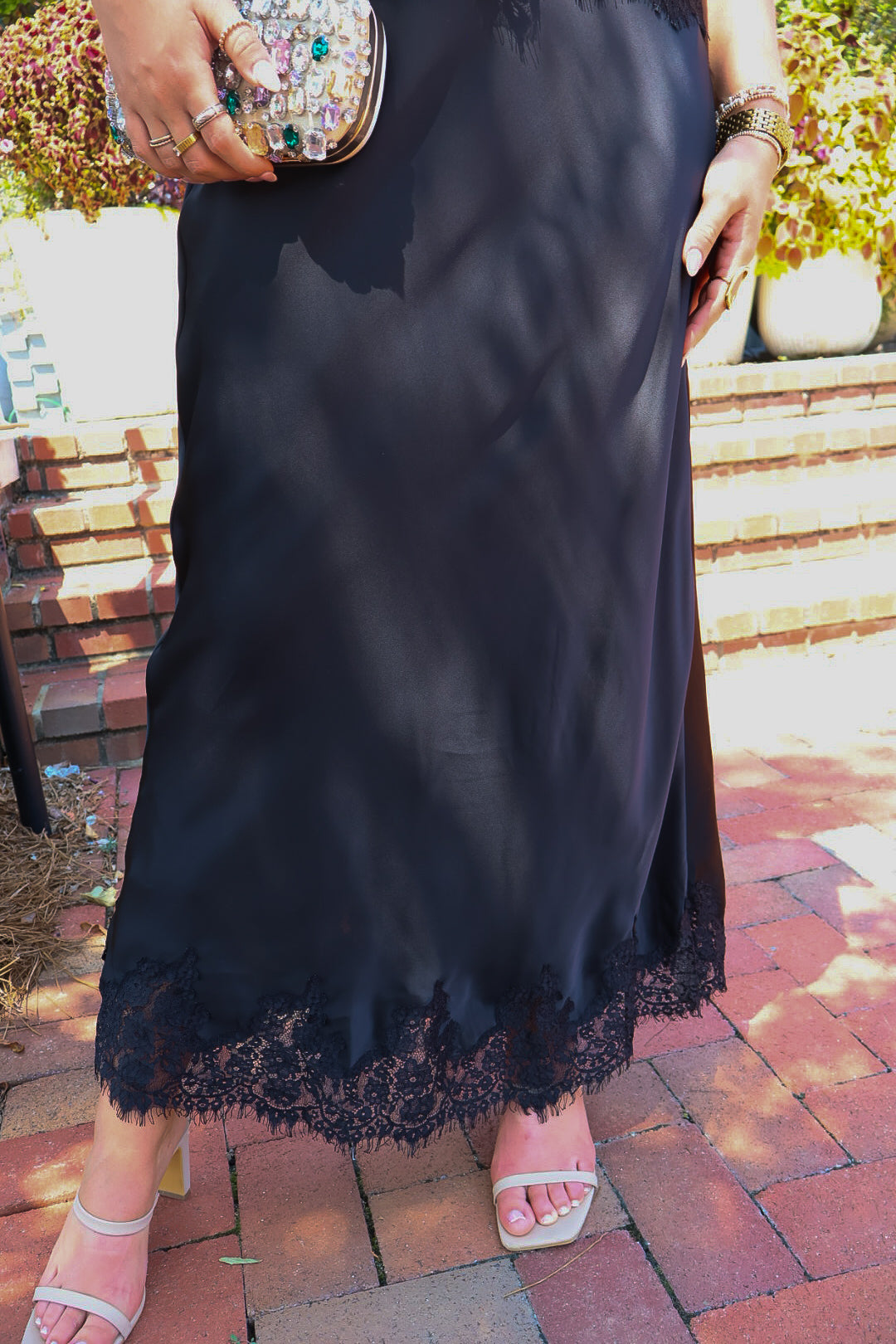 Black satin two-piece set with a lace-trim crop top and matching lace-trim skirt
