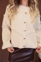 Cream Pom Pom Knit Cardigan — close-up of pom pom details and buttons.