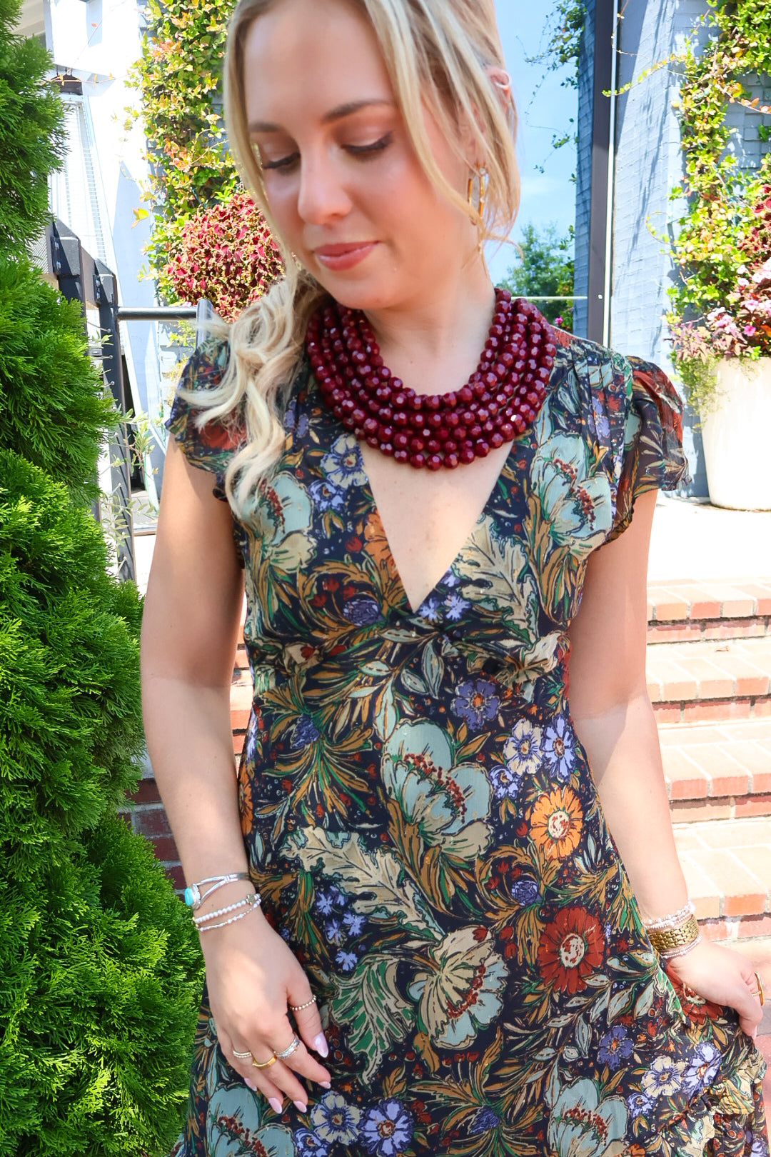 Bohemian floral maxi dress with a V-neck, flutter sleeves, and a tiered ruffle skirt