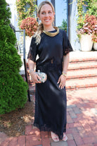 Black satin two-piece set with a lace-trim crop top and matching lace-trim skirt
