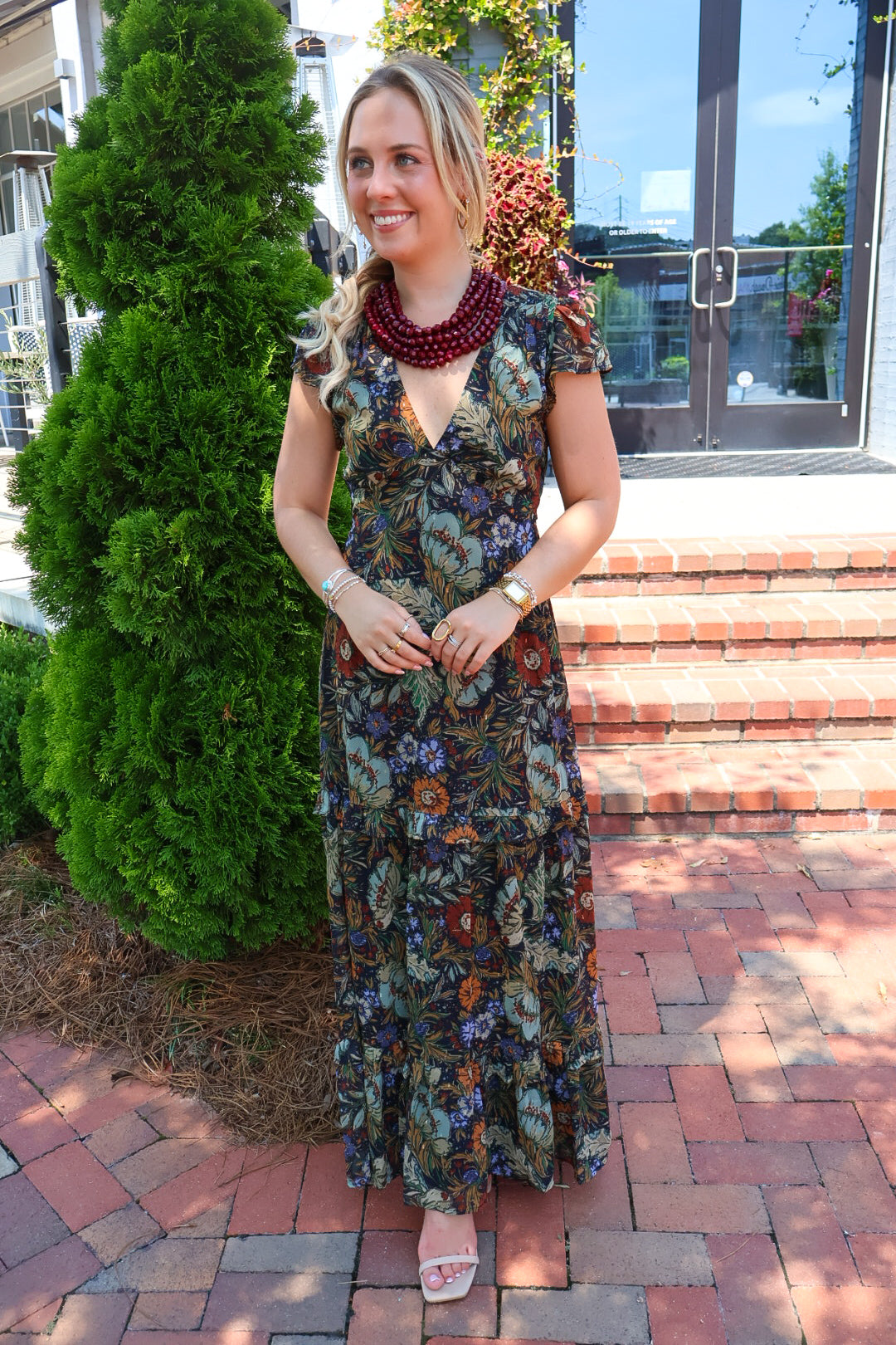 Bohemian floral maxi dress with a V-neck, flutter sleeves, and a tiered ruffle skirt