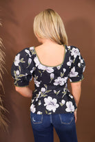 Model wearing the Black Floral Puff Sleeve Fitted Top from Moda Boutique