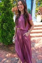 Mauve satin two-piece set with a boxy crop top and pleated midi skirt