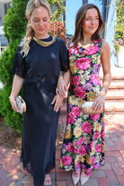 Black floral satin maxi dress with twisted straps and a draped cowl neckline