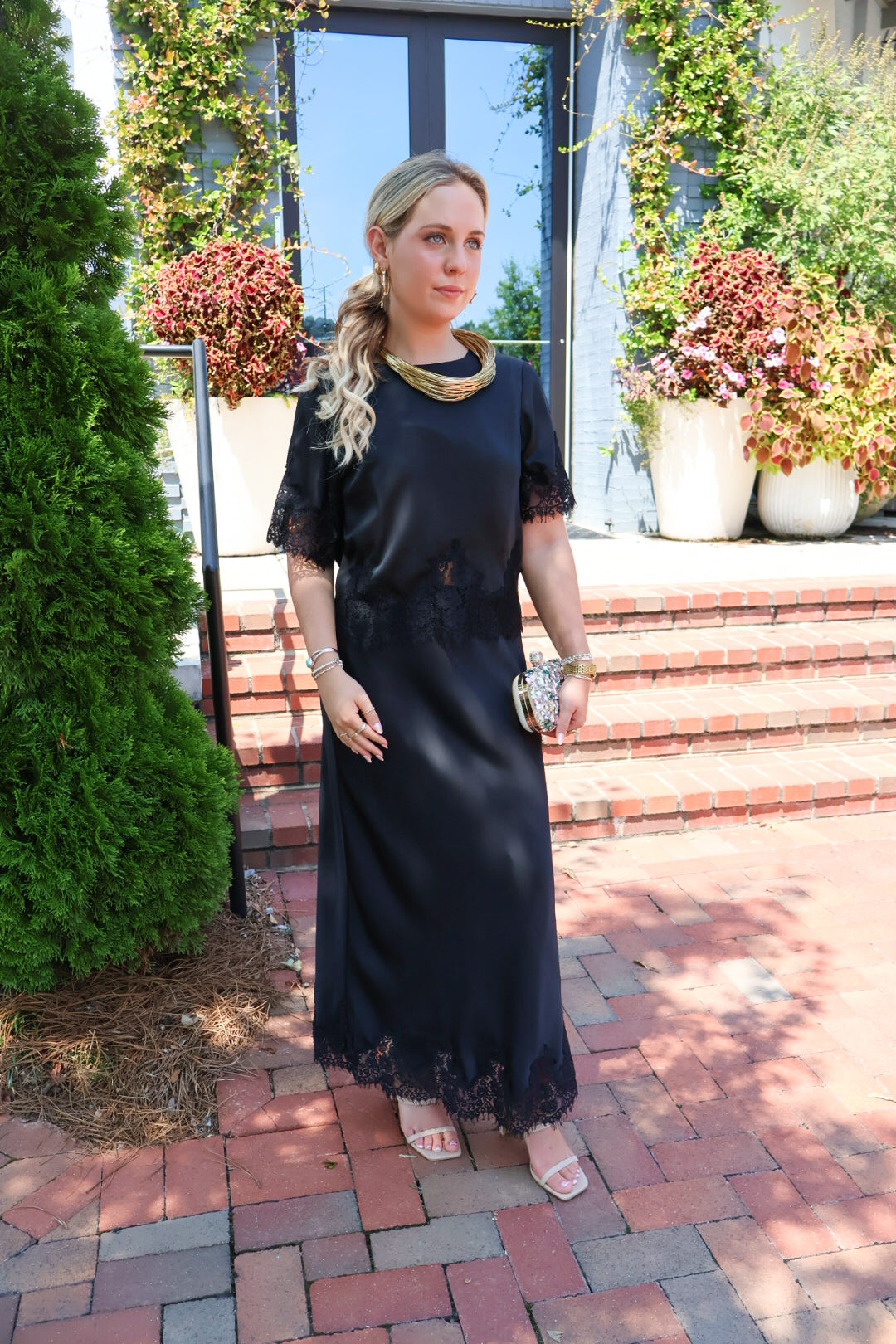Black satin two-piece set with a lace-trim crop top and matching lace-trim skirt