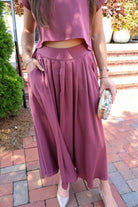 Mauve satin two-piece set with a boxy crop top and pleated midi skirt