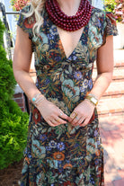 Bohemian floral maxi dress with a V-neck, flutter sleeves, and a tiered ruffle skirt