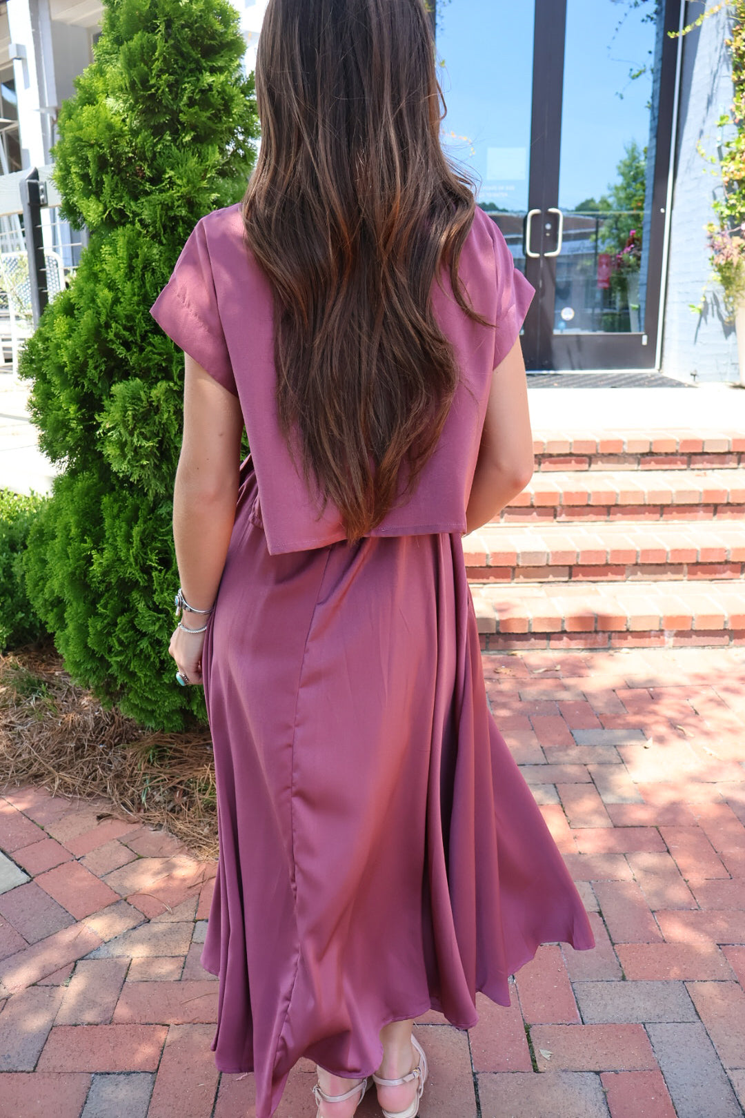 Mauve satin two-piece set with a boxy crop top and pleated midi skirt