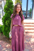 Mauve satin two-piece set with a boxy crop top and pleated midi skirt