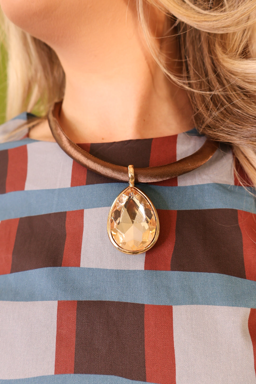 Champagne teardrop pendant on brown satin-look cord.