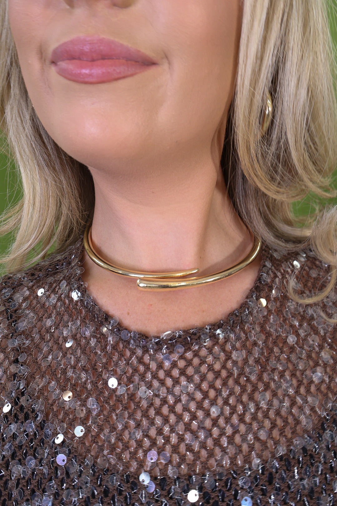 Gold-tone open collar necklace with overlapping tapered ends.