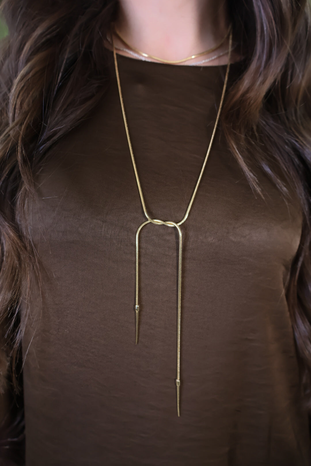 Gold-tone lariat necklace with loop and long drop ends.