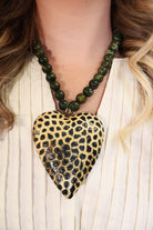 Oversized spotted wooden heart pendant on green beaded necklace