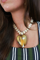 Reversible two-tone heart necklace shown on amber side